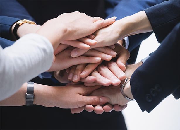 Hands stacked together symbolizing teamwork and collective effort